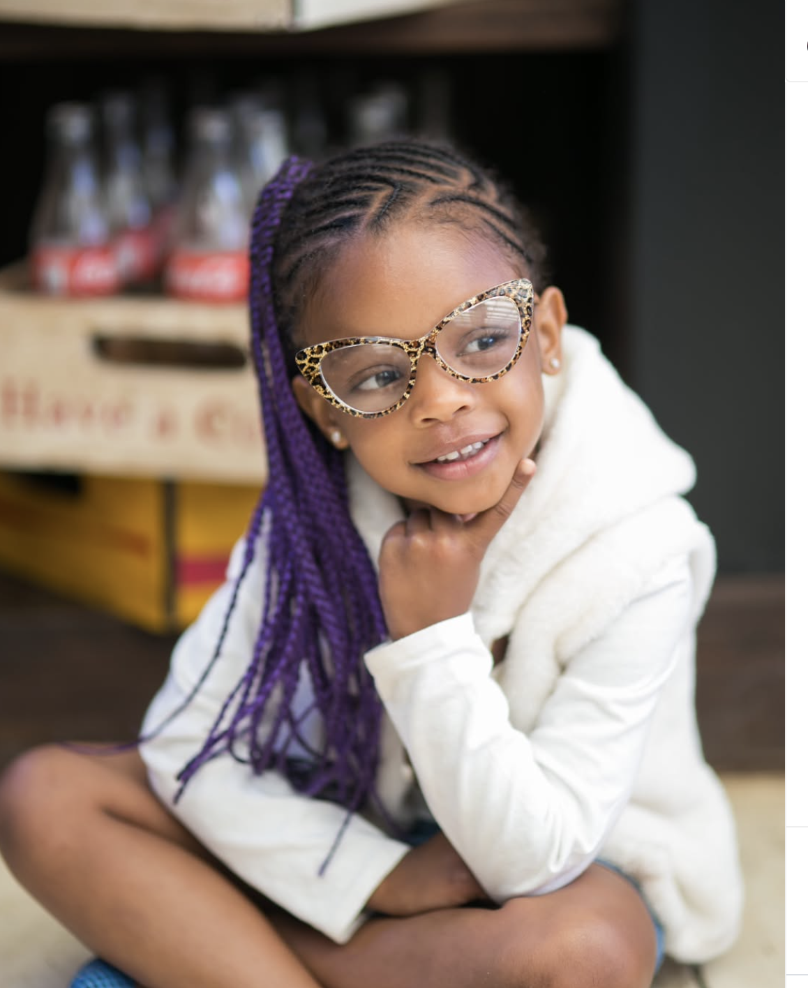 Happy child with purple braids and glasses at Kids Nook